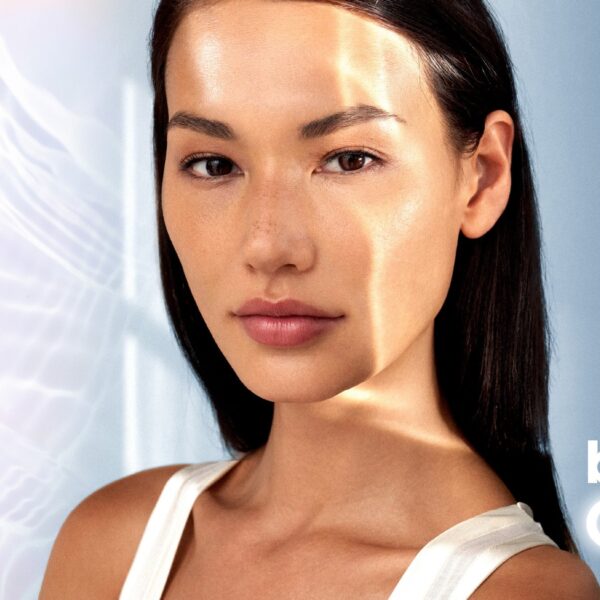 Woman with luminous skin resting her hand against her face, illustrating the Teoxane babyGLOW 8-point technique.